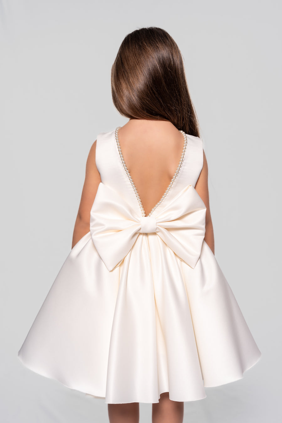 White satin dress embellished with pearls and a ribbon