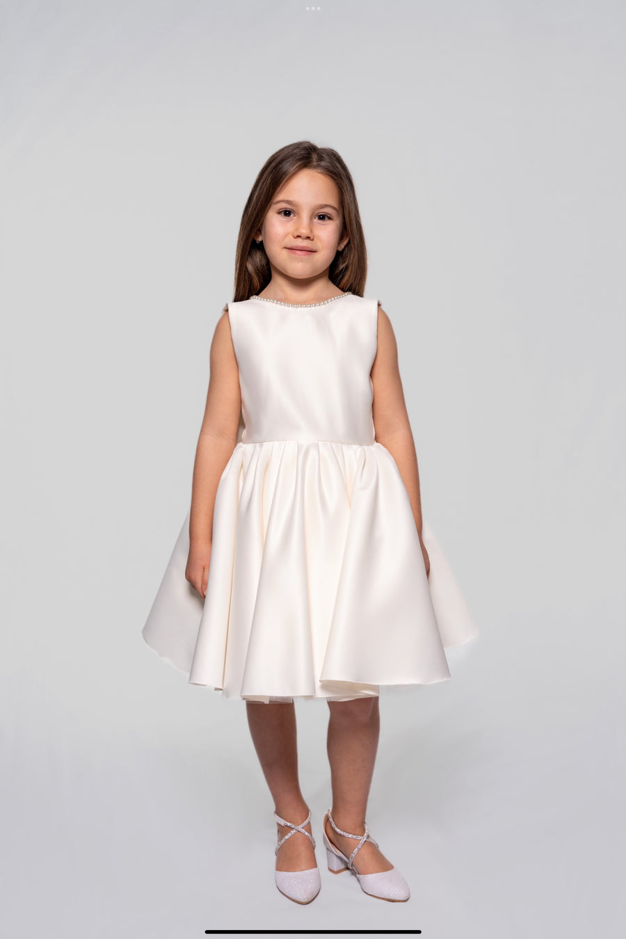 White satin dress embellished with pearls and a ribbon